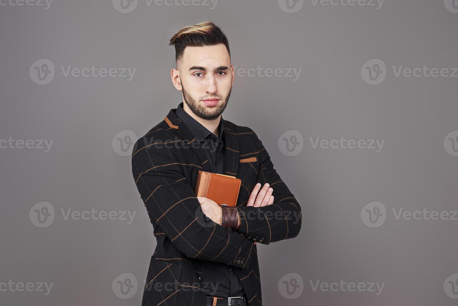 portret van een knappe, bebaarde man met een boek op handen foto