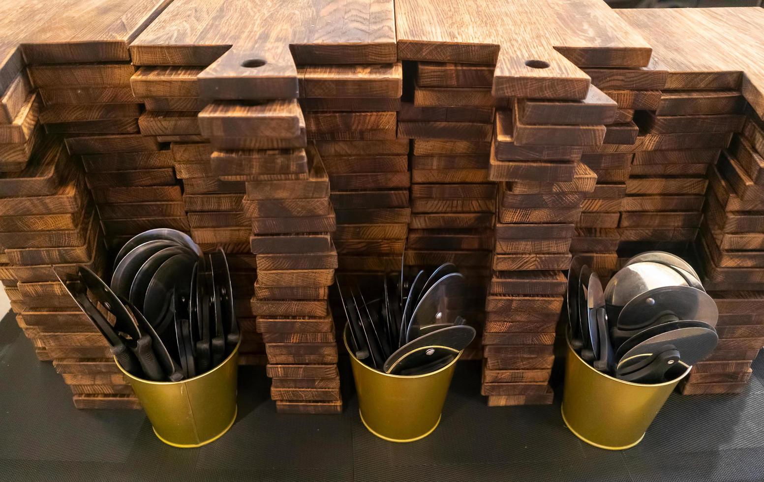 stapel houten snijplanken, metalen emmers met snijders voor pizza foto