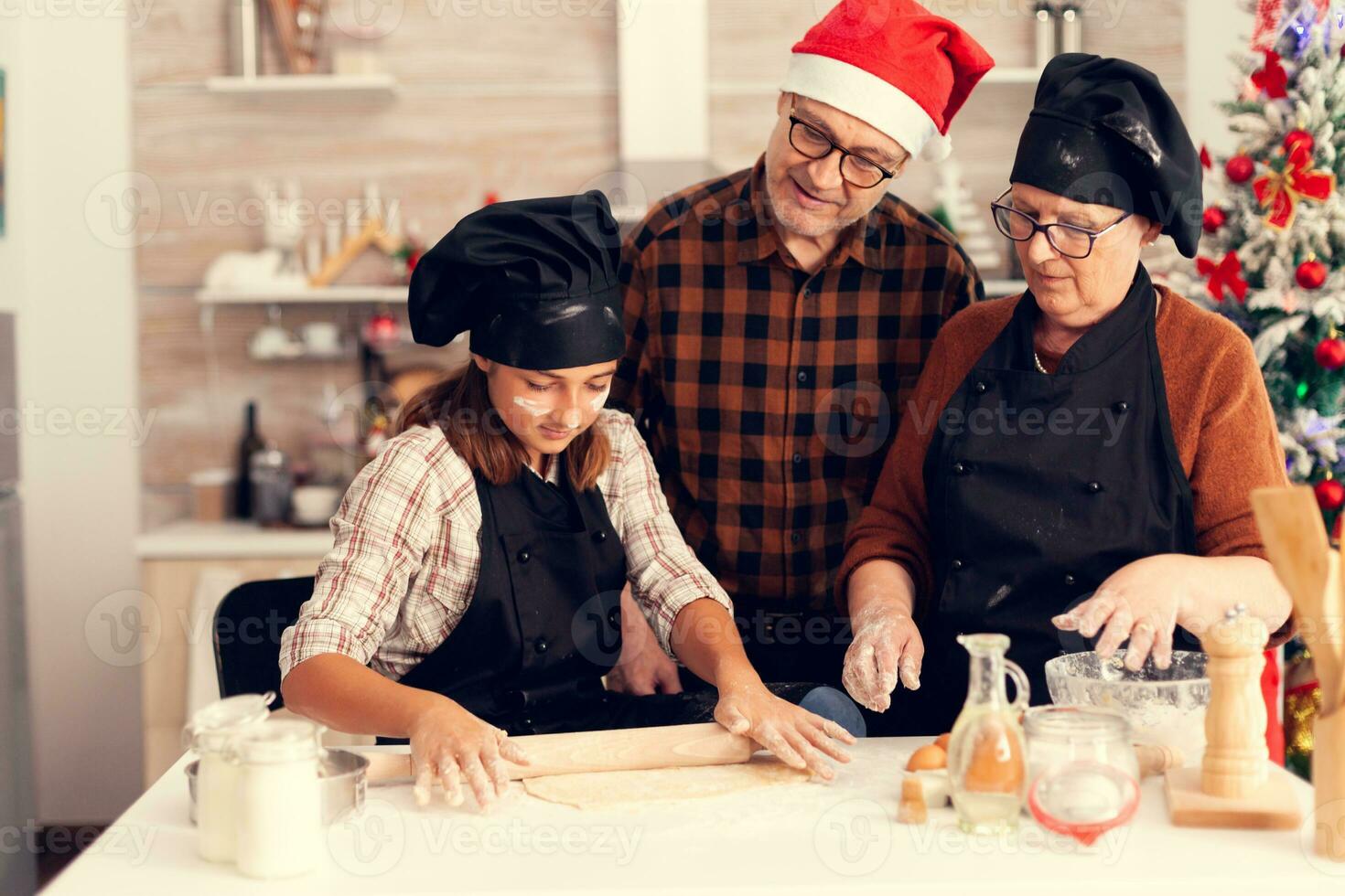 grootouder Aan Kerstmis dag op zoek Bij kind maken nagerecht. gelukkig vrolijk vrolijk tiener- meisje helpen senior vrouw voorbereidingen treffen zoet koekjes naar vieren winter vakantie. foto