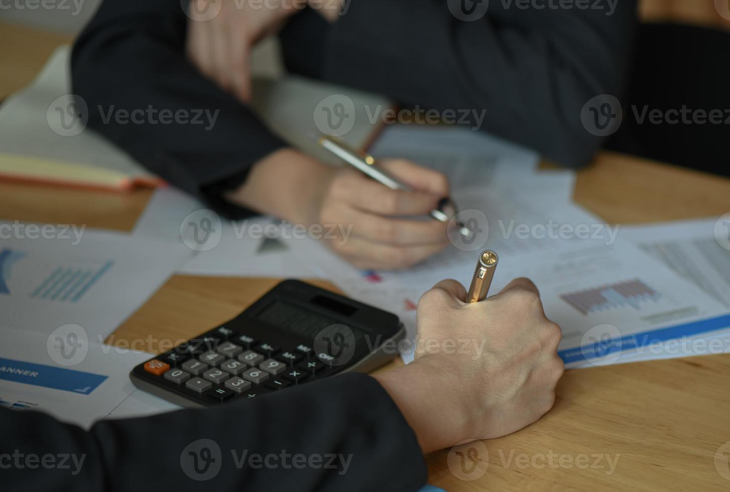 vrouwelijk accountantsteam analyseert de gegevens om het budget samen te vatten. foto