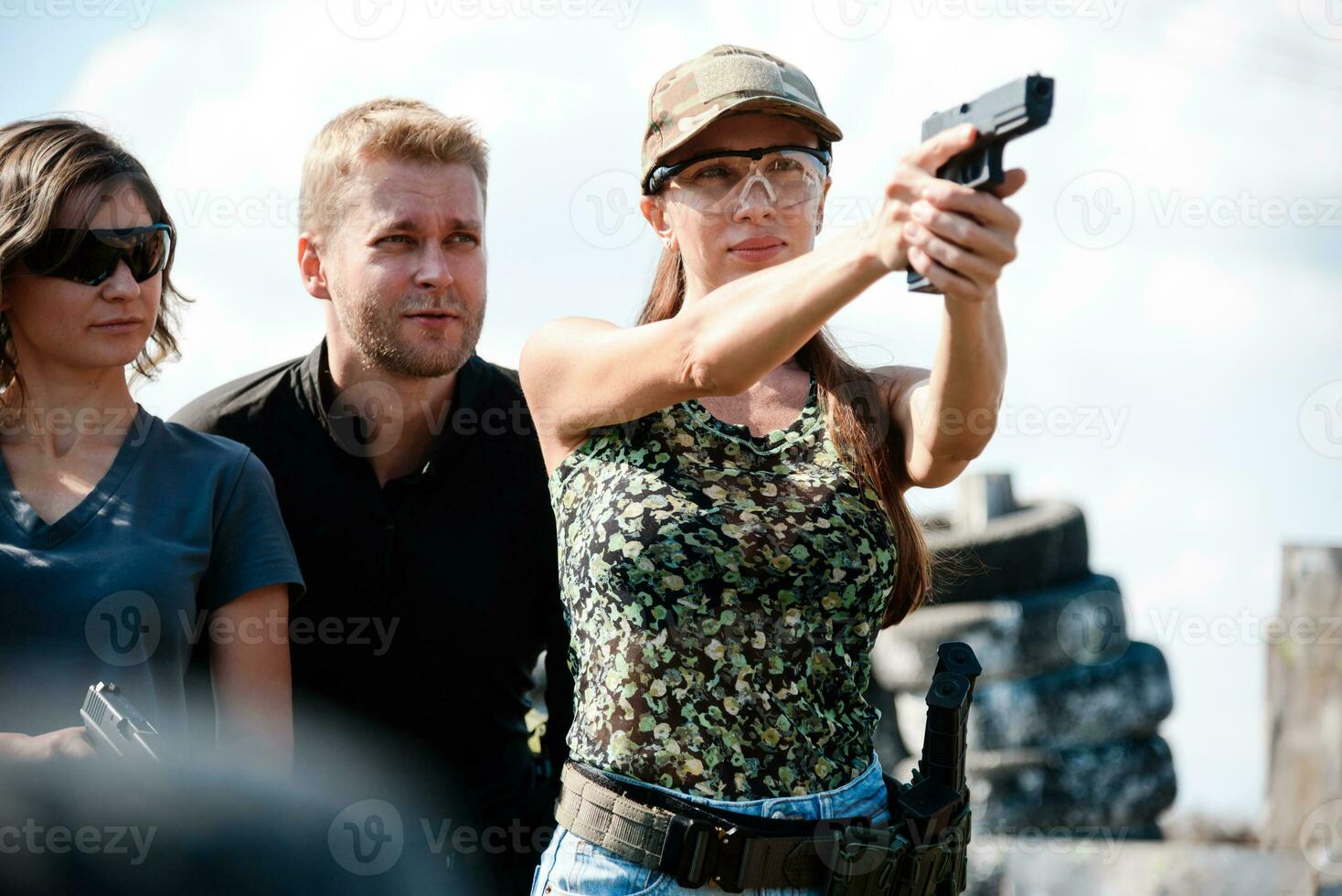 een wapens instructeur geeft les een meisjes naar schieten een pistool Bij een schieten reeks foto