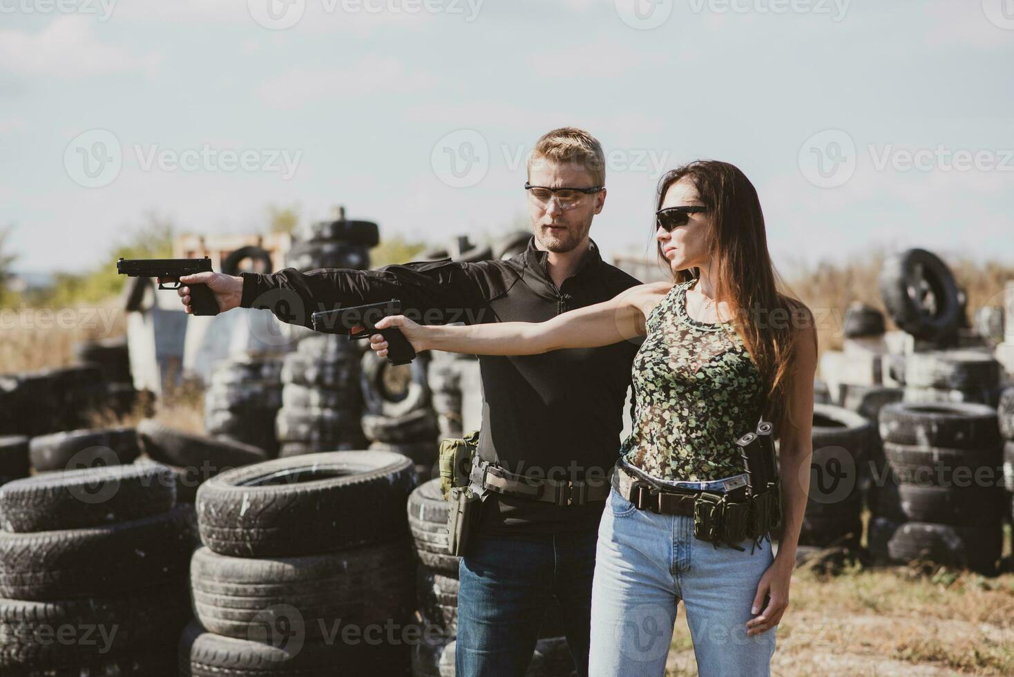 een wapens instructeur geeft les een meisje naar schieten een pistool Bij een schieten reeks foto