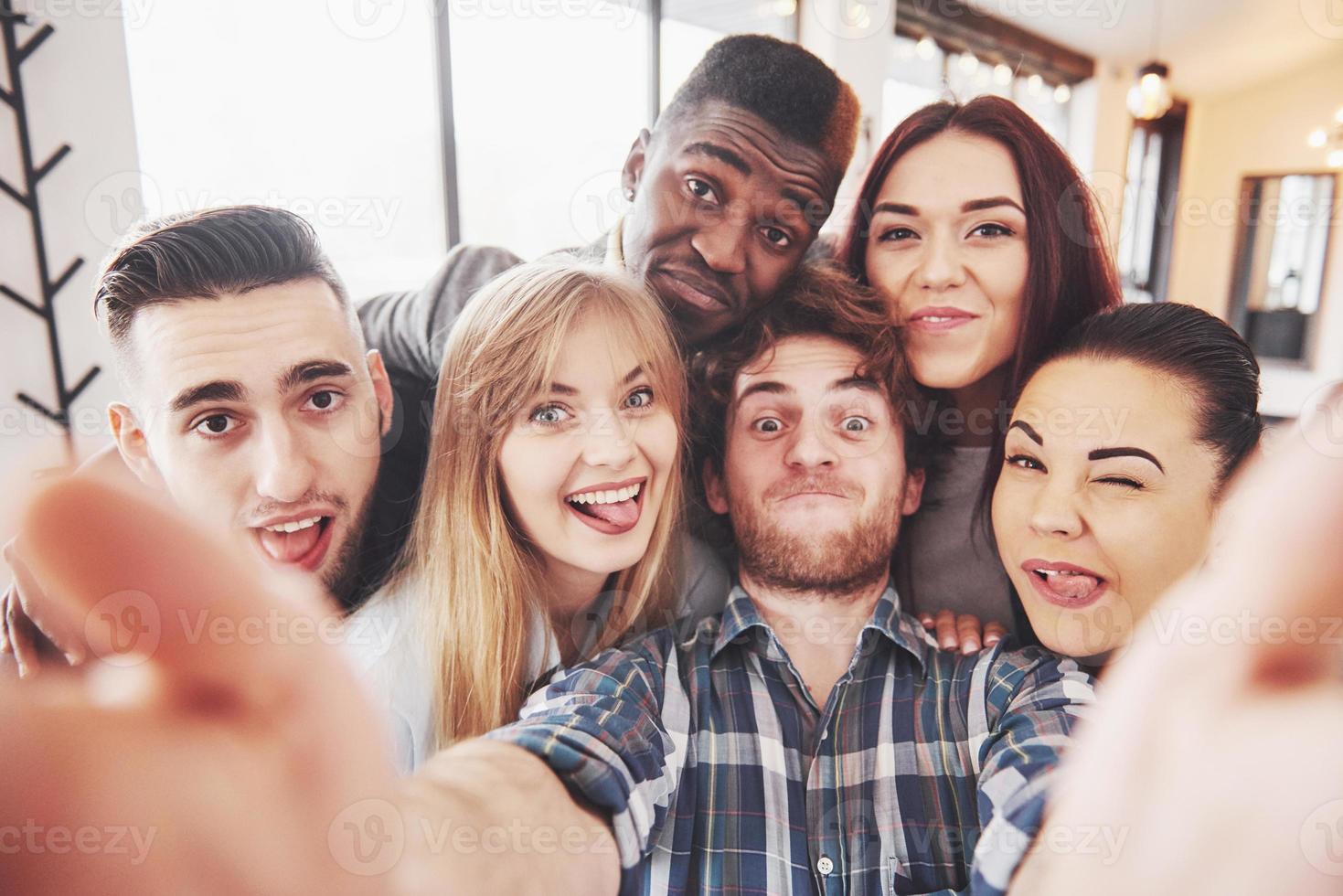 selfie van jonge lachende tieners die samen plezier hebben. beste vrienden nemen selfie buitenshuis met achtergrondverlichting. gelukkig vriendschapsconcept met jonge mensen die samen plezier hebben foto