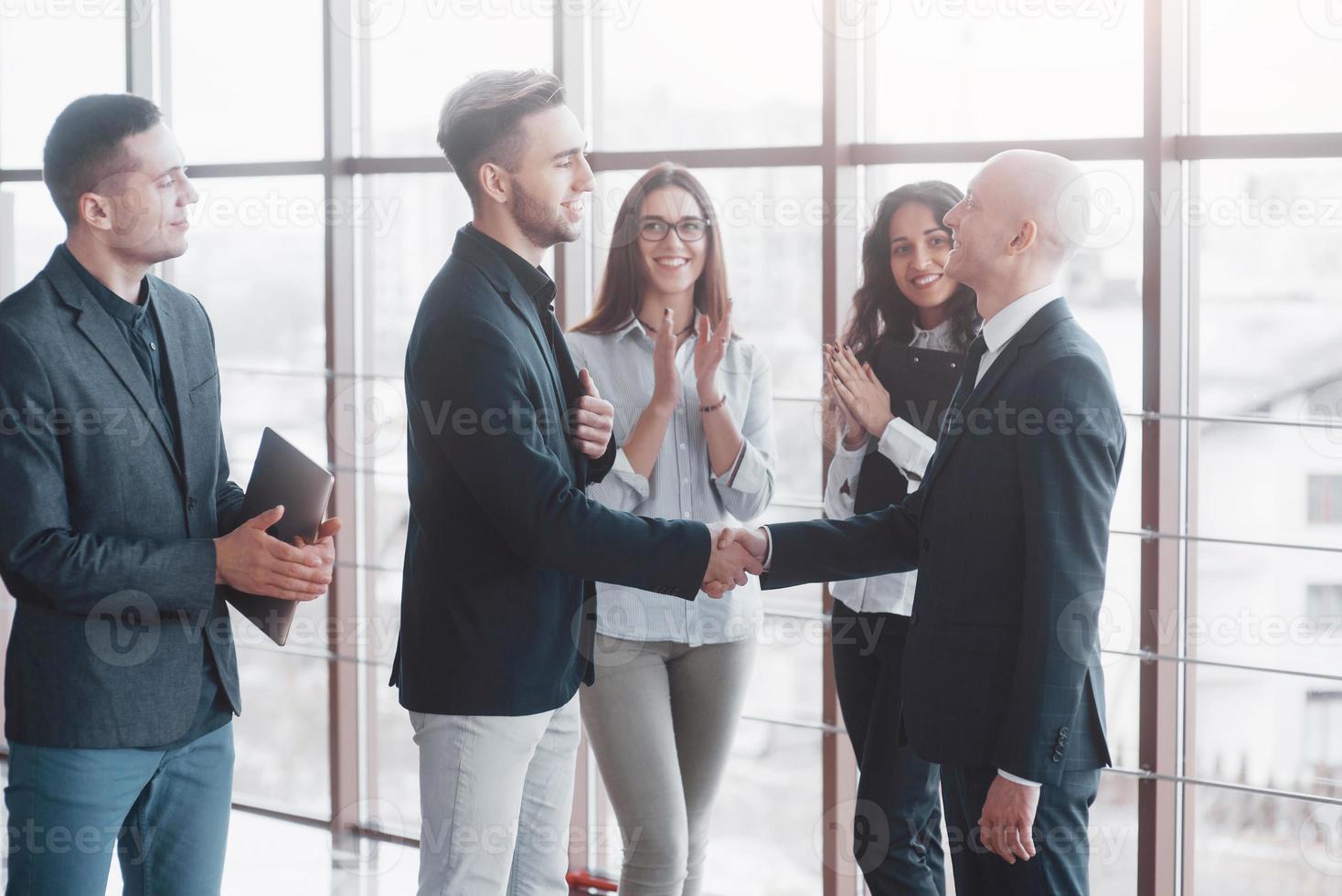 twee zelfverzekerde zakenman die handen schudt tijdens een vergadering op kantoor, succes, dealen, begroeten en partnerconcept foto