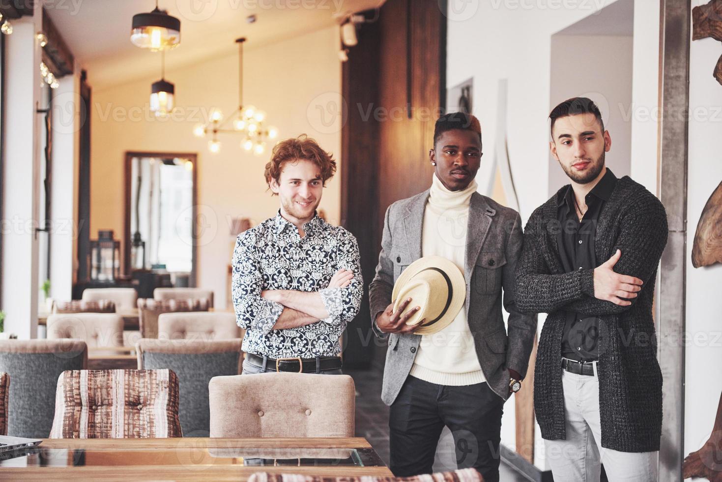 drie vrolijke jonge mannen die samen staan en glimlachen foto