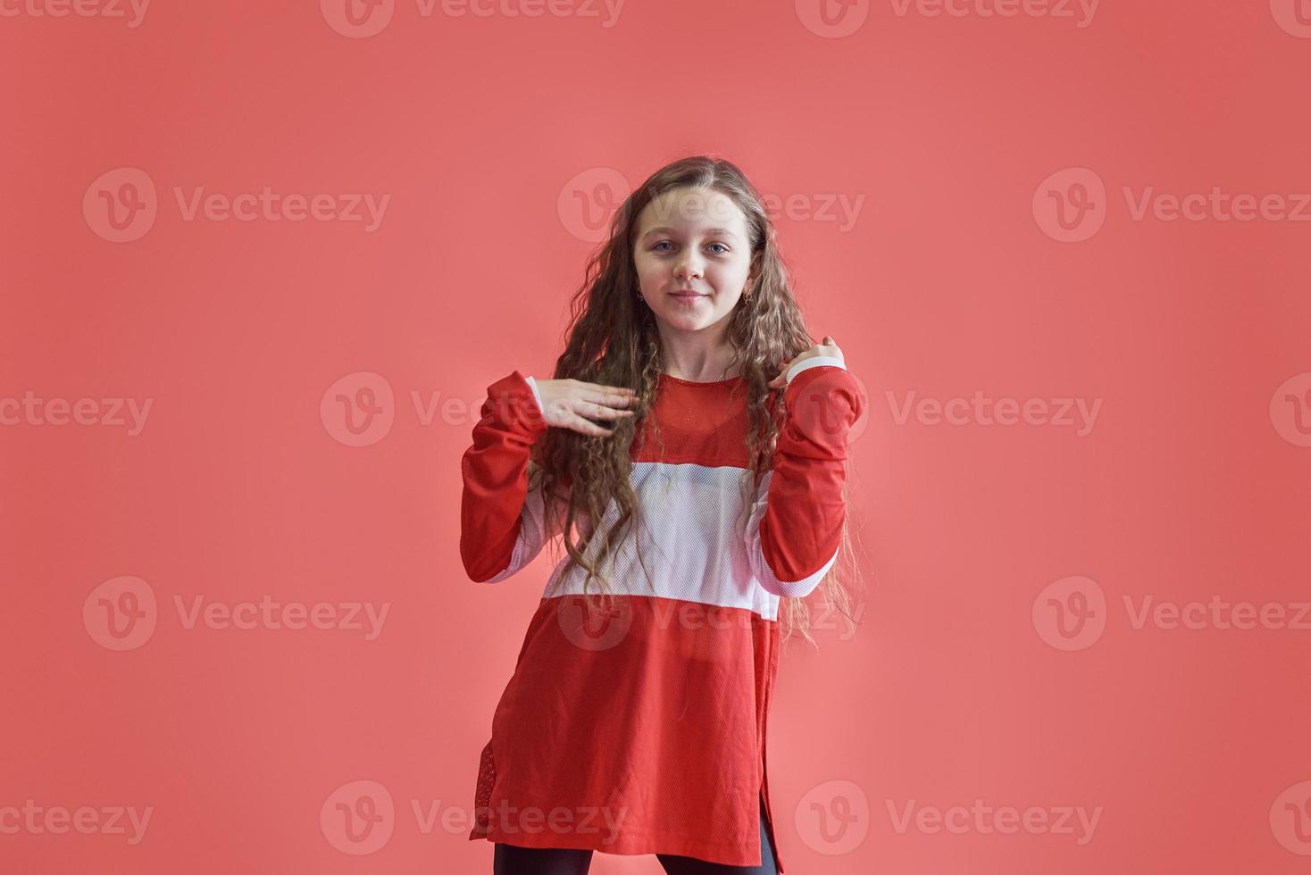 jonge stedelijke vrouw dansen op rode achtergrond, moderne slanke hiphop-stijl tienermeisje foto