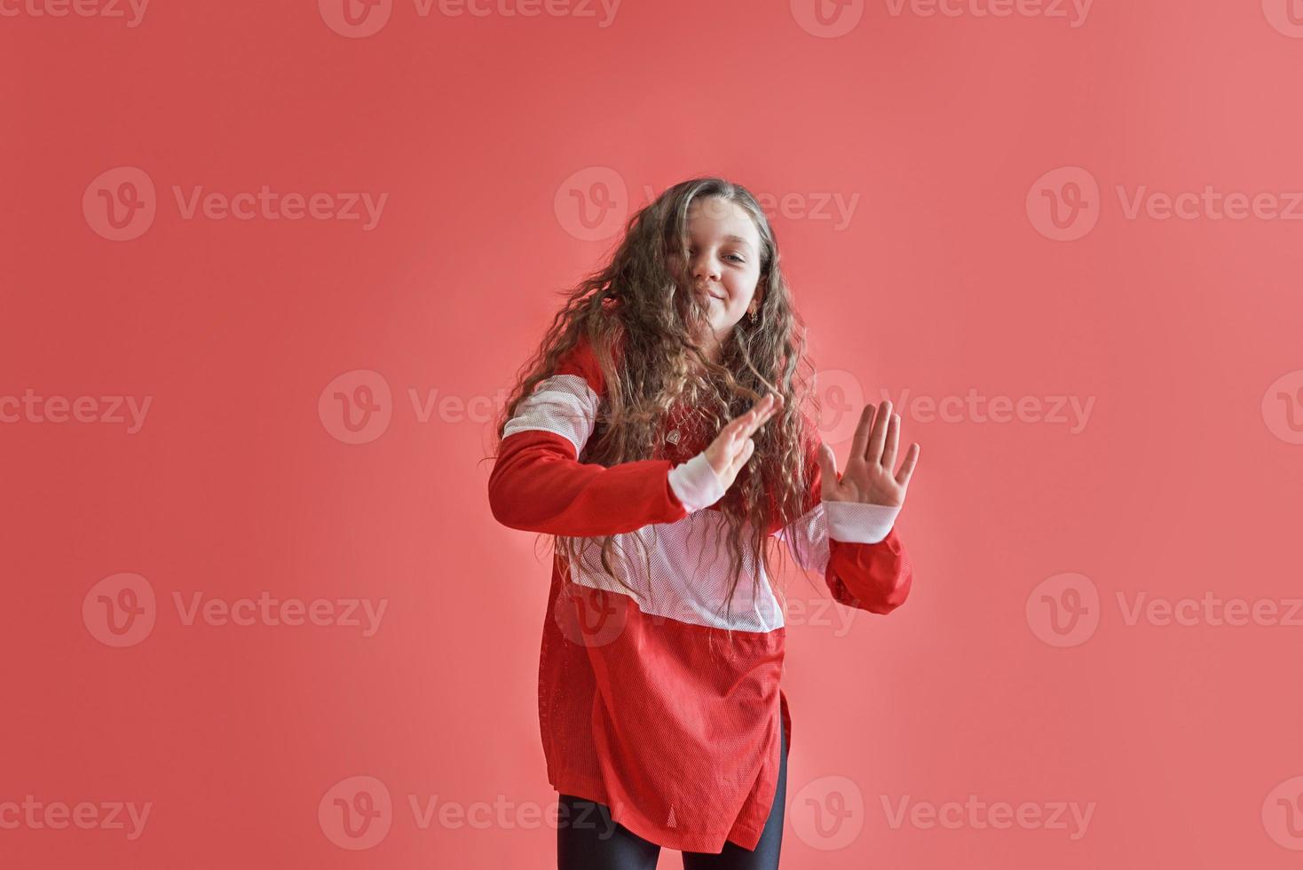 jonge stedelijke vrouw dansen op rode achtergrond, moderne slanke hiphop-stijl tienermeisje foto