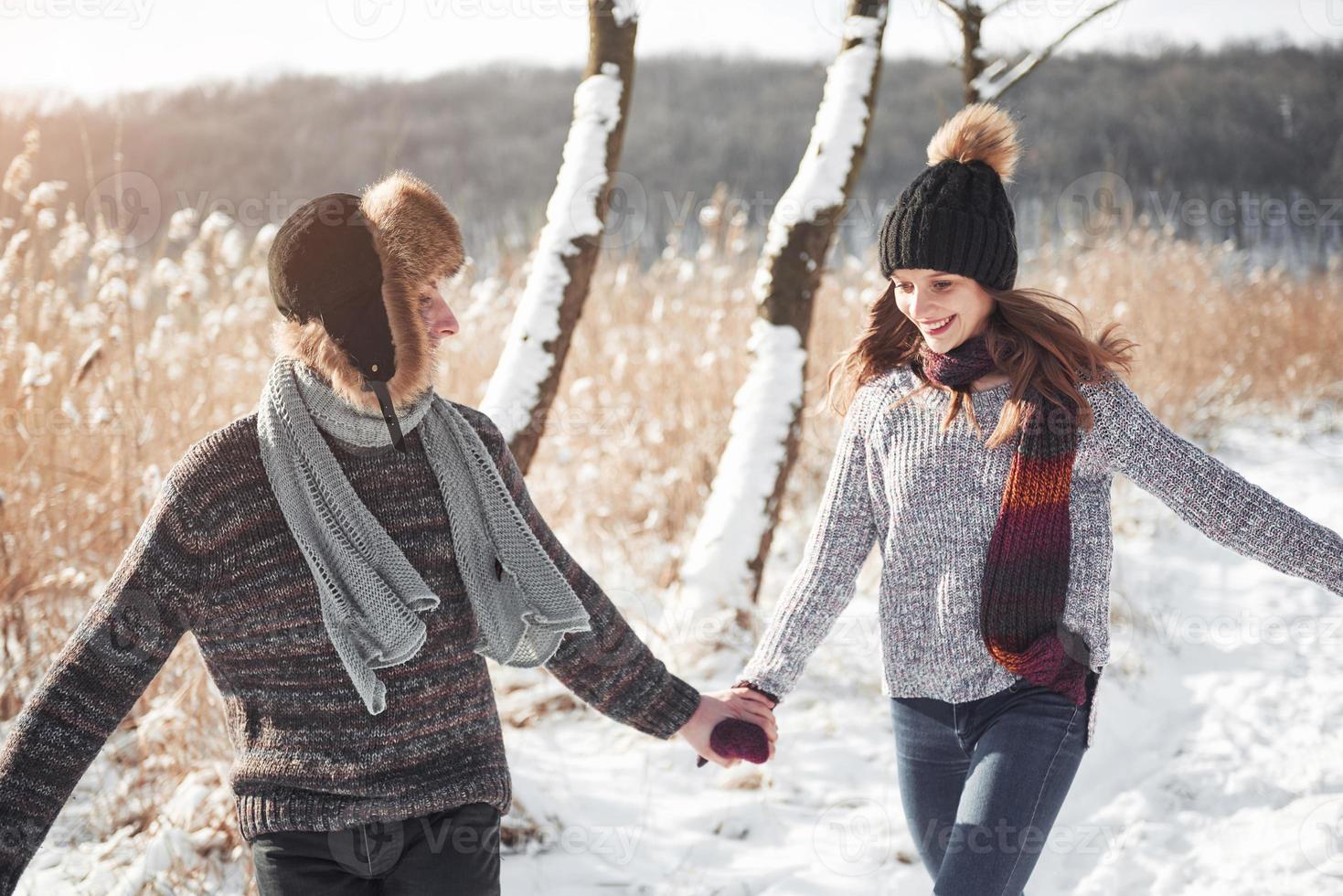 paar heeft plezier en lacht. kus. jonge hipster paar knuffelen elkaar in winter park. winter liefdesverhaal, een mooi stijlvol jong stel. wintermodeconcept met vriend en vriendin foto