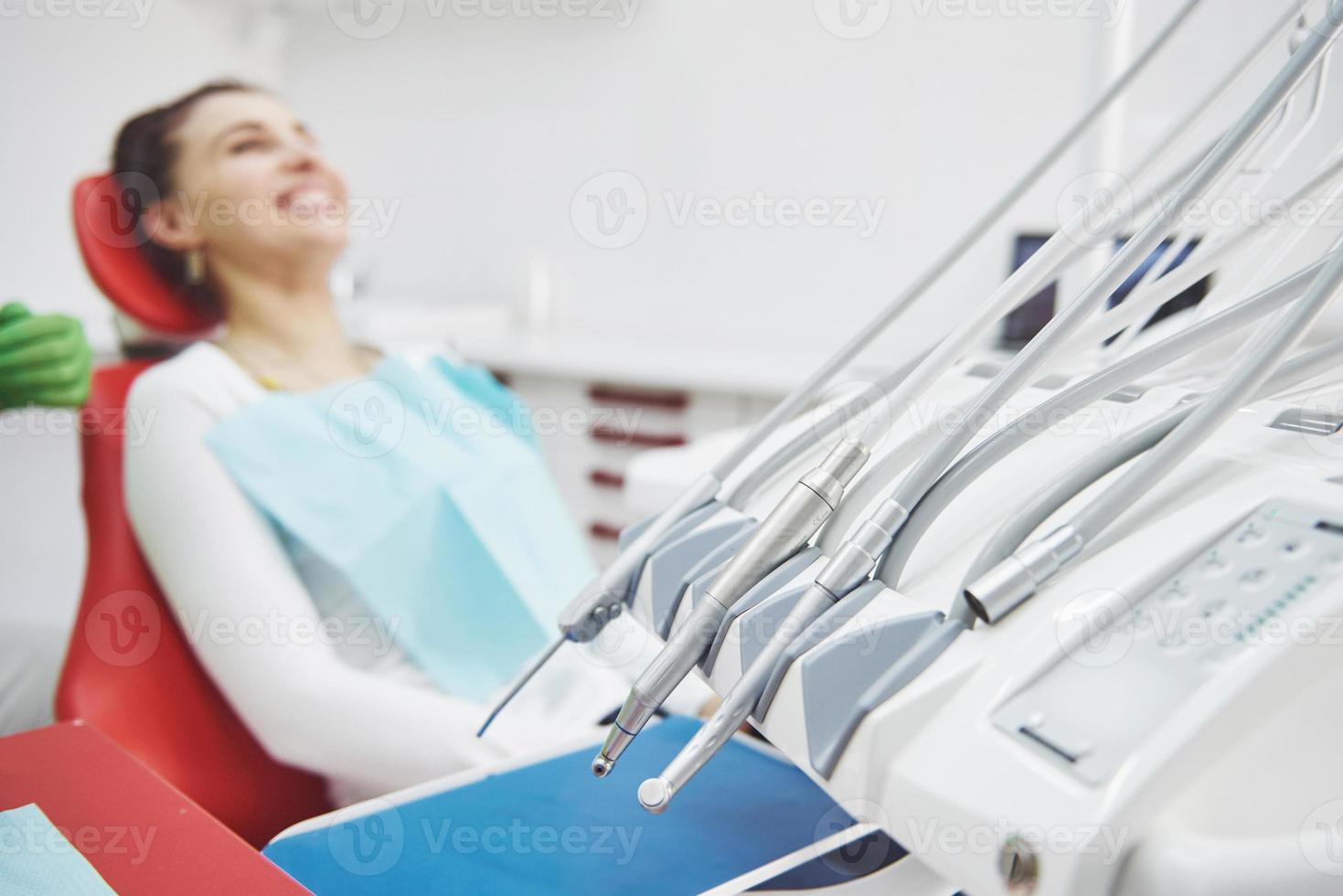 jonge vrouwelijke patiënt zittend op een stoel in tandheelkundige office.preparing voor tandheelkundig examen foto