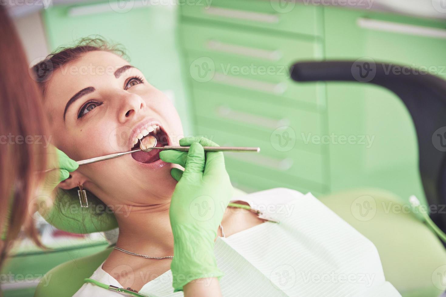tandarts die een vrouwelijke patiënt in de stomatologie geneest. concept voor vroege preventie en mondhygiëne foto