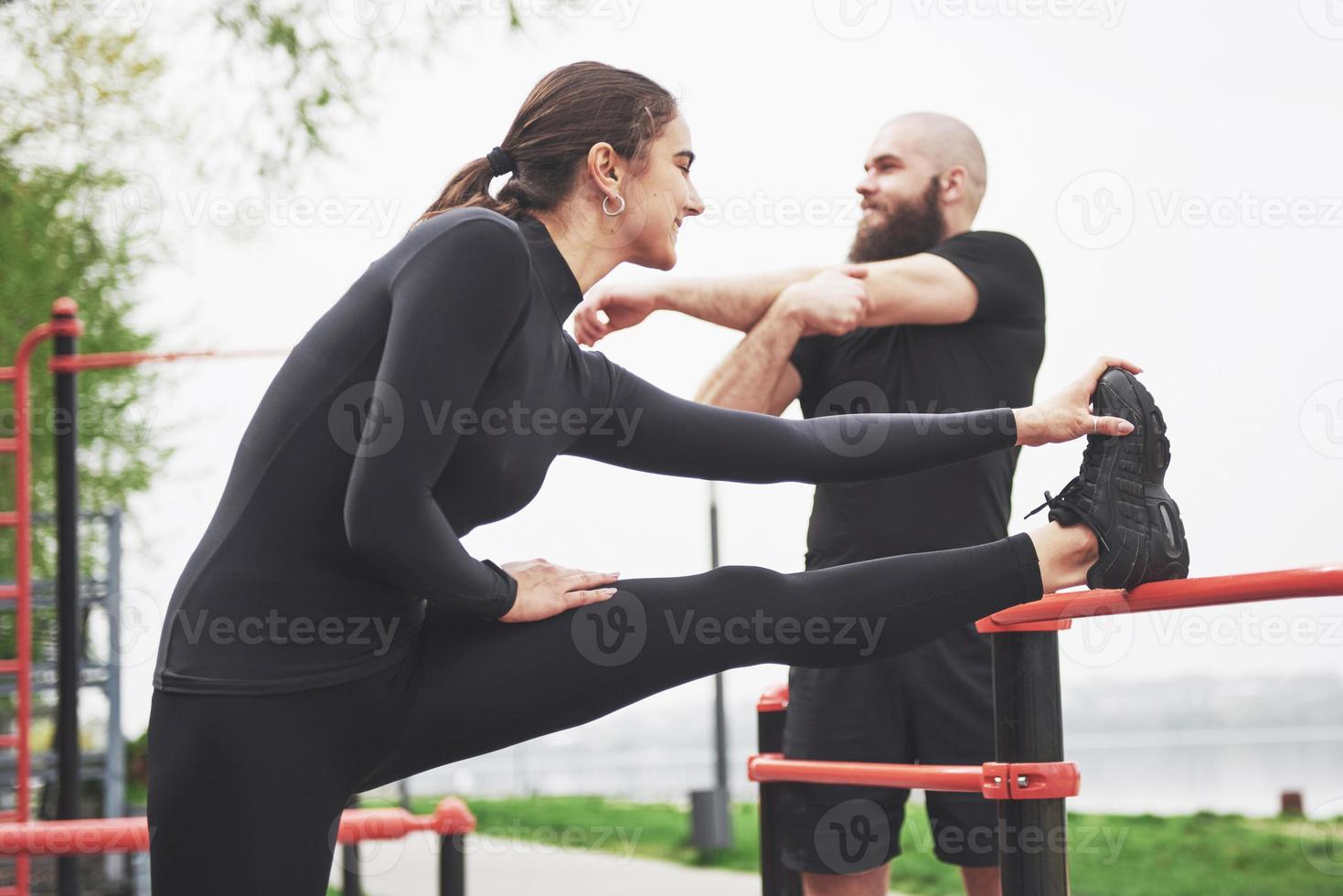 jonge man en vrouw voeren oefeningen en striae uit voordat ze gaan sporten foto