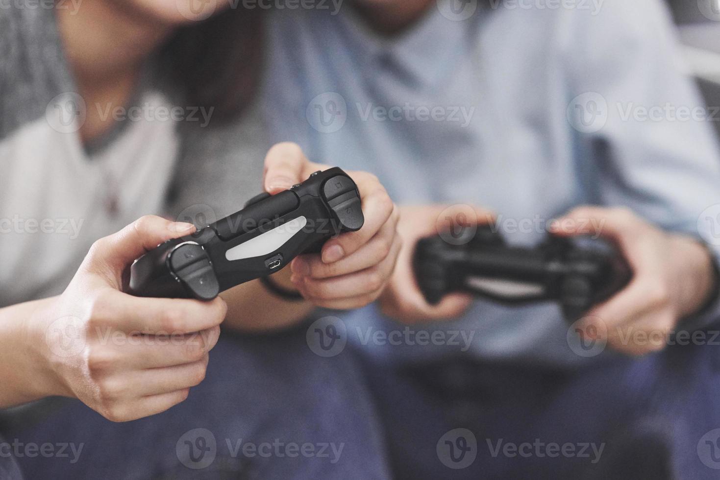 tweelingzusjes spelen op de console. meisjes houden joysticks in hun handen en hebben plezier foto