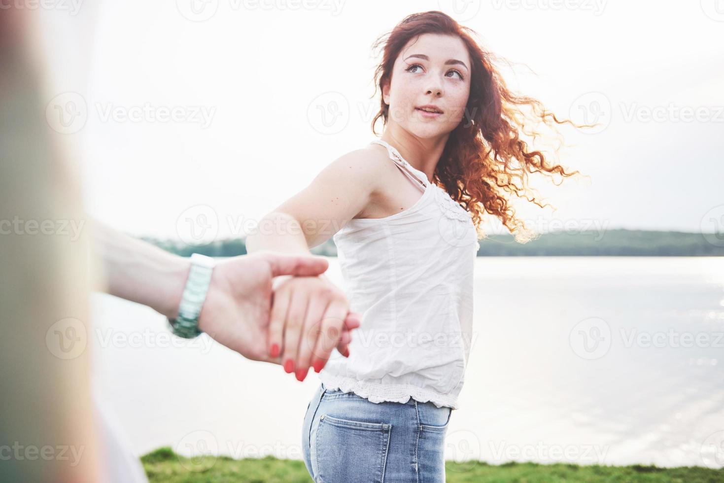 een lachende gelukkige vrouw met een speelse uitdrukking en een hand met haar man. foto