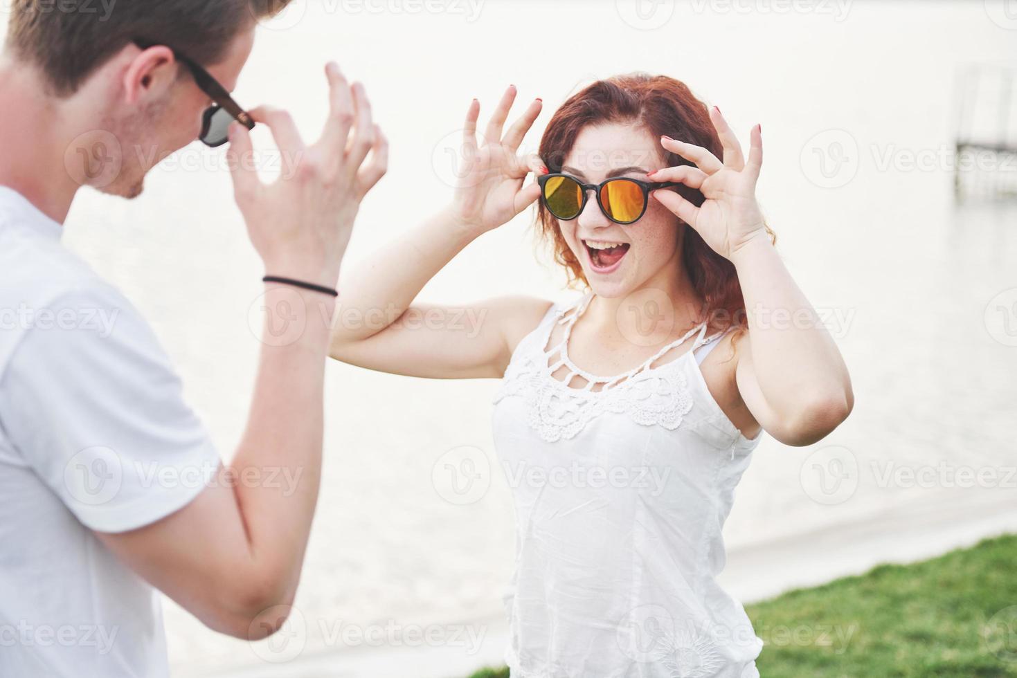 vrolijke, speelse vrouw met haar man in zonnebril foto
