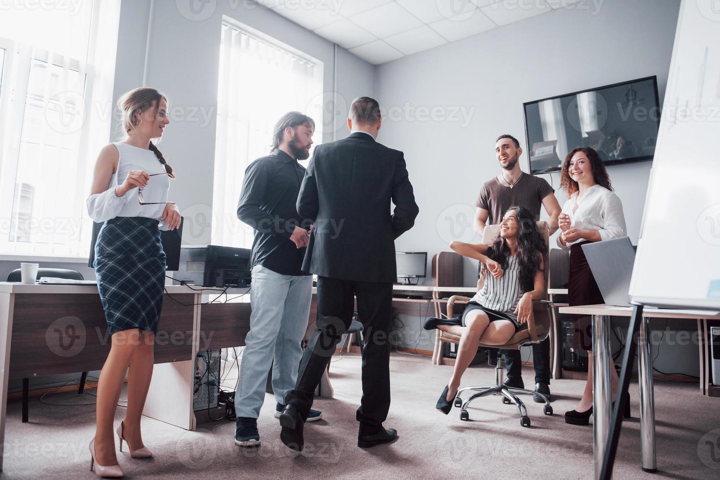 een groep zakenmensen vieren, plezier maken, op kantoor. foto