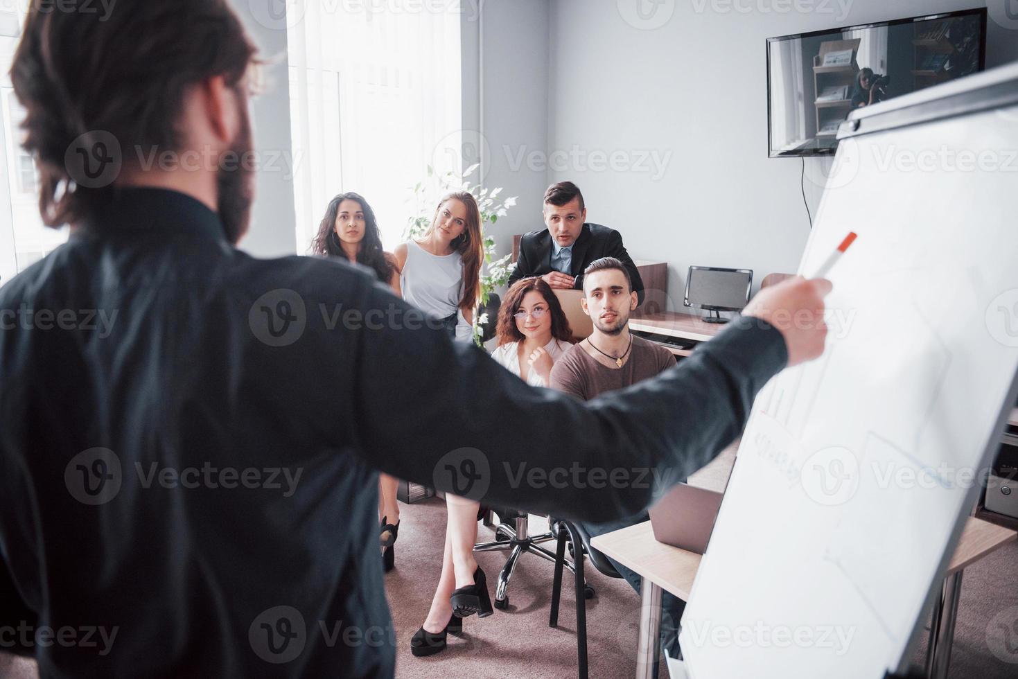 portret van een gelukkig creatief team van mensen die tijdens de vergadering op kantoor praten. foto