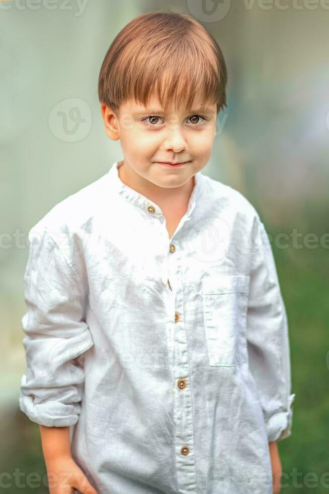 een jong knap jongen van Europese uiterlijk geniet uitgeven tijd Aan de groen gazon Bij huis. zijn een Super goed tijd naar kom tot rust. foto