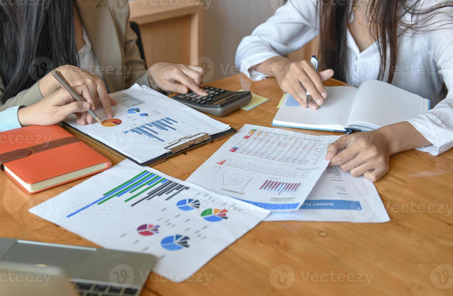 vrouwelijk kantoorpersoneelsteam vat het budget voor de jaarlijkse directiepresentatie samen. foto