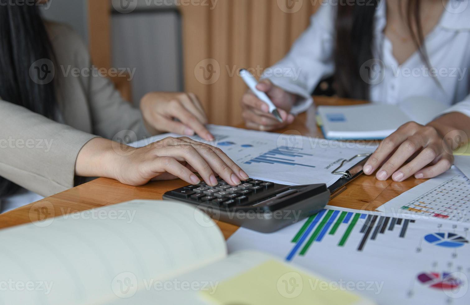 vrouwelijk kantoorpersoneelsteam vat het budget voor de jaarlijkse directiepresentatie samen. foto