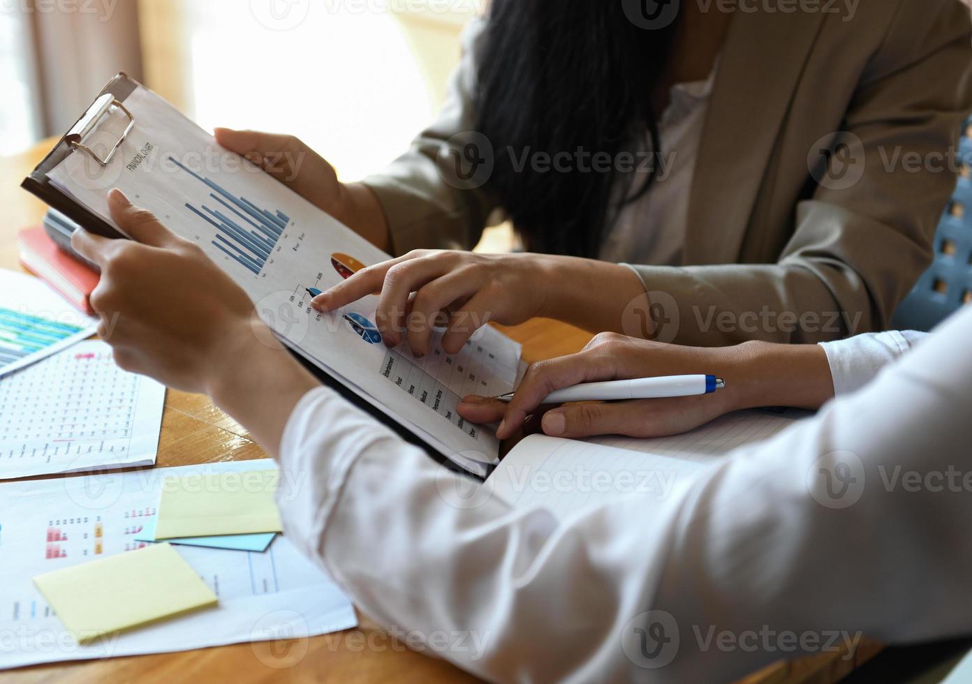 vrouwelijke kantoormedewerker die bestand vasthoudt. Ze analyseren de grafiek. foto