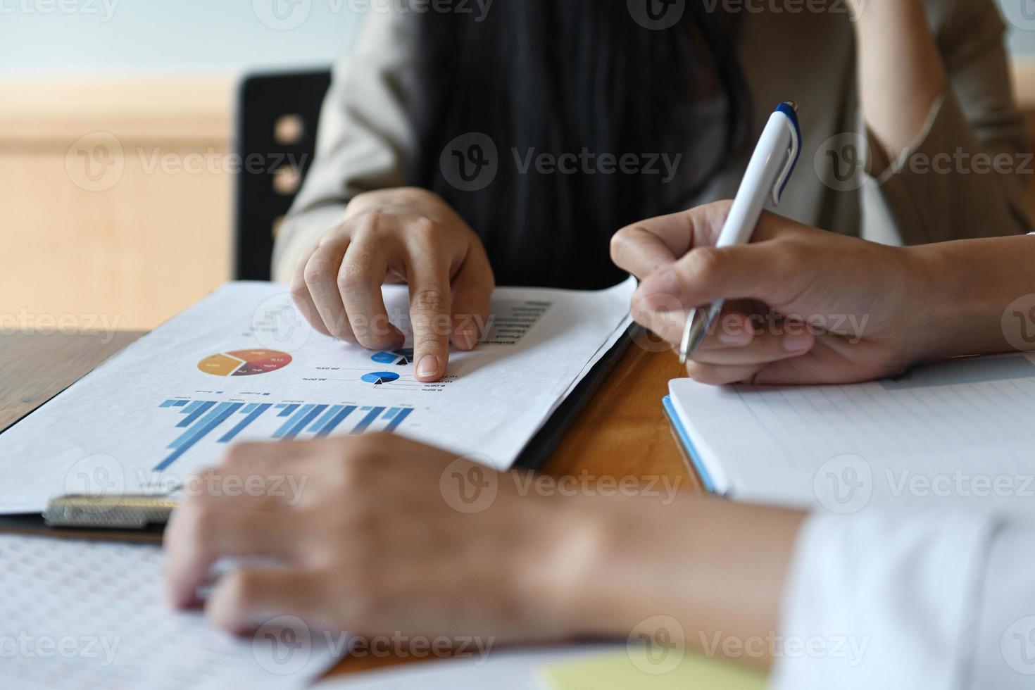 vrouwelijk kantoorpersoneelsteam vat het budget voor de jaarlijkse directiepresentatie samen. foto