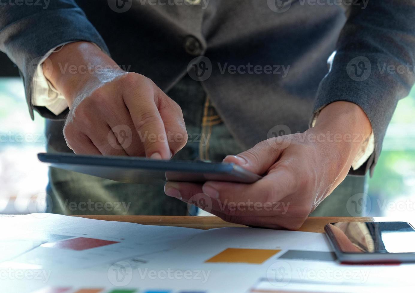 zakenmensen die aan een bureau werken en een tablet met touchscreen gebruiken. foto