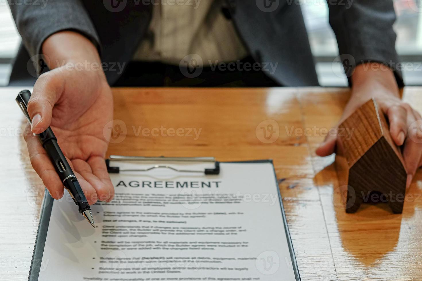 verkoper behandelt de pen die naar het overeenkomstdocument wijst zodat de klant het contract.real estate bedrijfsconcept kan ondertekenen. foto