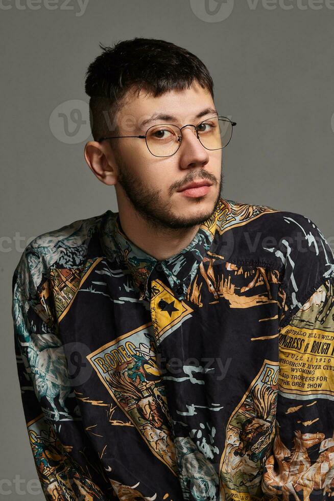 detailopname portret van een grappig vent poseren in studio geïsoleerd Aan een grijs achtergrond. foto