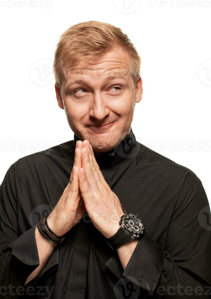 jong blond Mens in een zwart shirt, horloges en armband is maken gezichten, geïsoleerd Aan een wit achtergrond foto