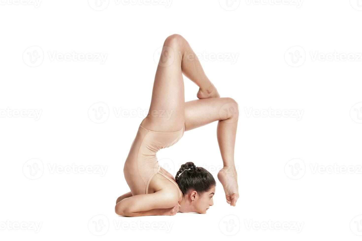 flexibel meisje gymnast in beige turnpakje is het uitvoeren van complex elementen van gymnastiek terwijl poseren geïsoleerd Aan wit achtergrond. detailopname. foto