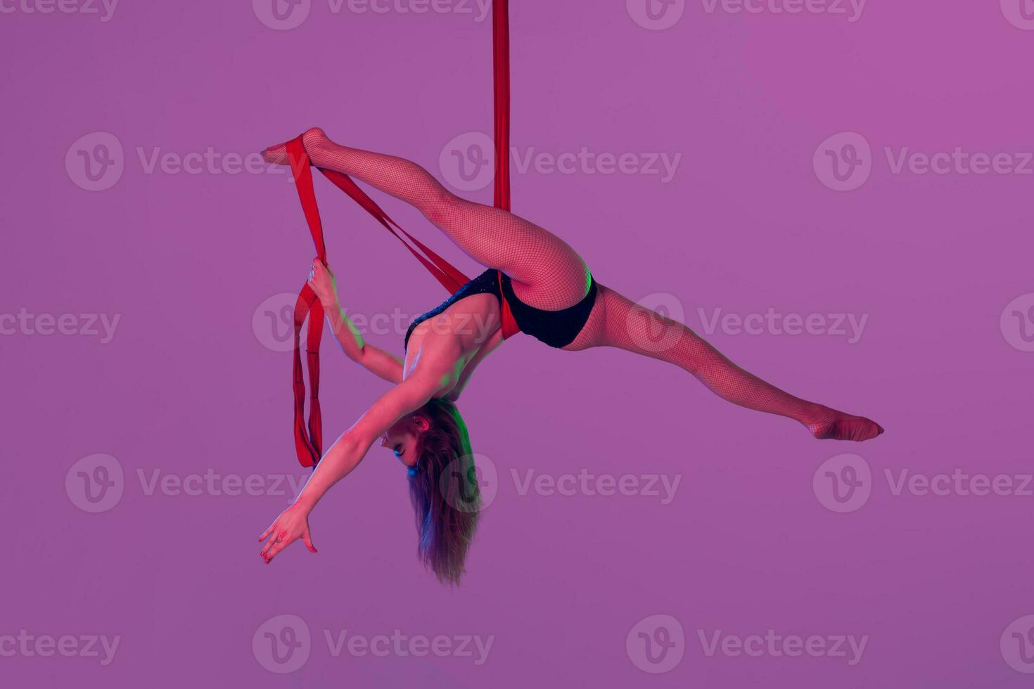 mooi meisje in een zwart zwempak is het uitvoeren van een acrobatisch elementen in studio. foto