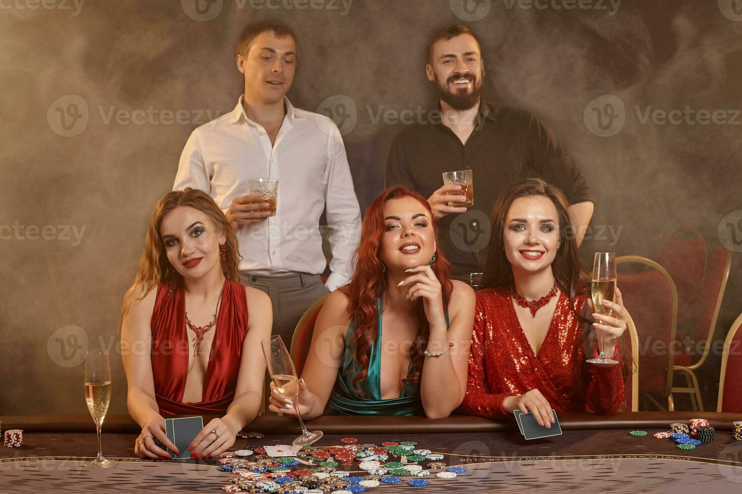 groep van een jong rijk vrienden zijn spelen poker Bij een casino. foto