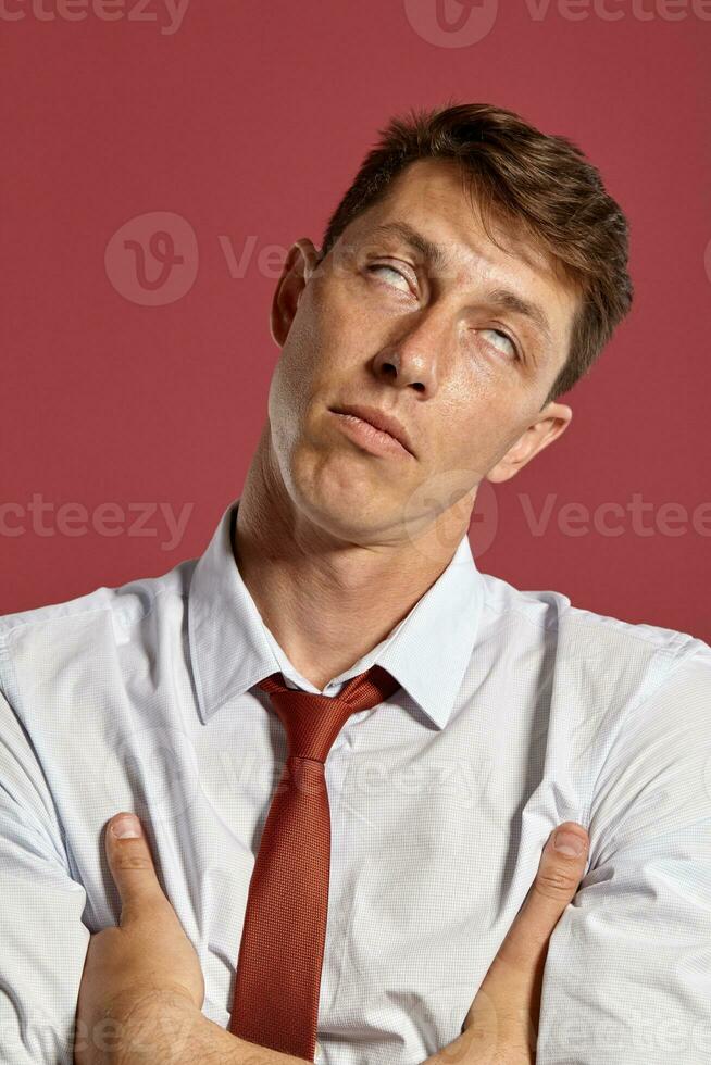 portret van een jong brunet Mens poseren in een studio tegen een rood achtergrond. foto