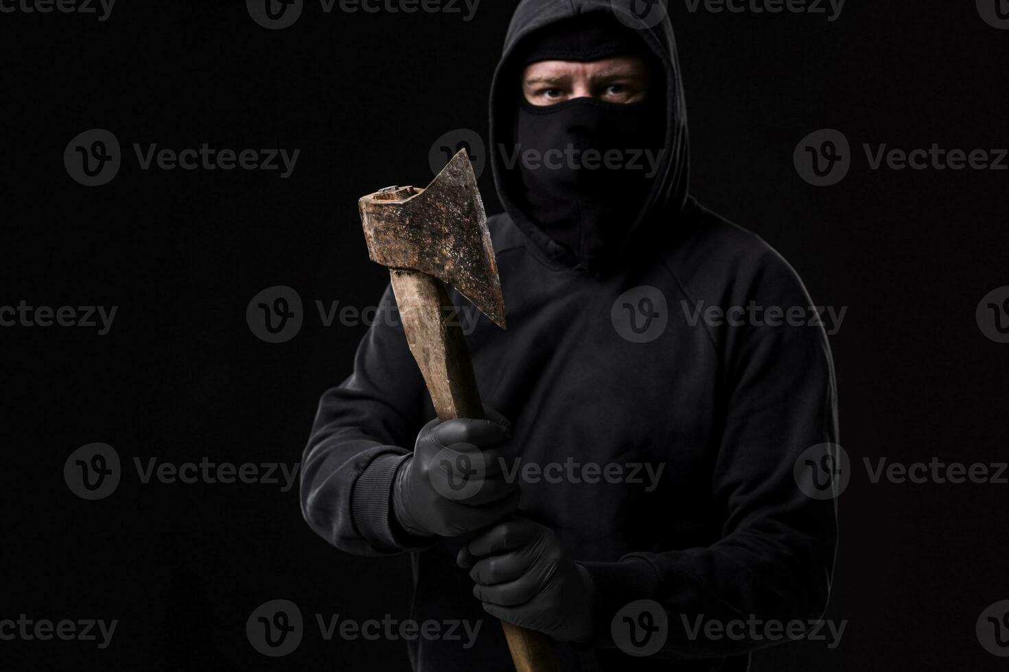 bandiet in zwart masker met bijl Aan zwart achtergrond foto