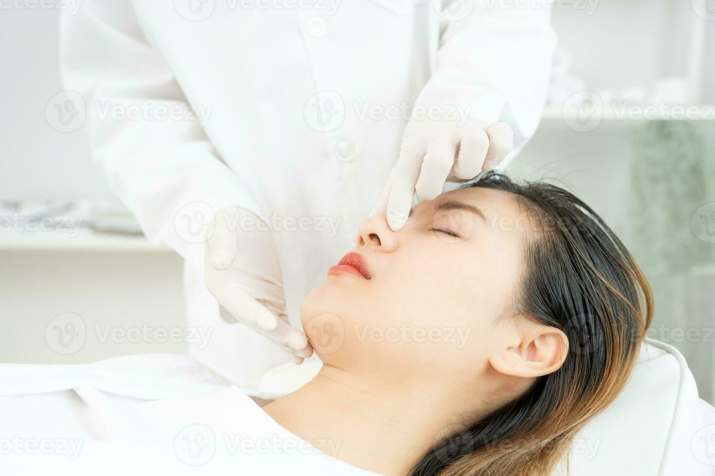 plastic chirurgie, schoonheid, chirurg of schoonheidsspecialist aanraken vrouw gezicht, chirurgisch procedure dat bij betrekken veranderen vorm van neus, dokter onderzoekt geduldig neus- voordat neuscorrectie, medisch bijstand, Gezondheid foto