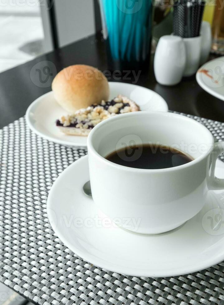 zwart koffie met brood Aan tafel foto