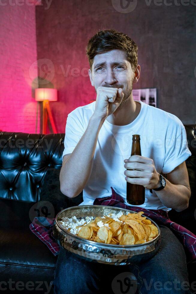 jong supporter Mens aan het kijken Amerikaans voetbal spel Aan televisie zittend foto