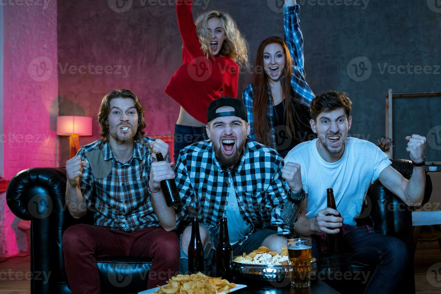 groep van vrienden aan het kijken TV bij elkaar passen Bij huis foto