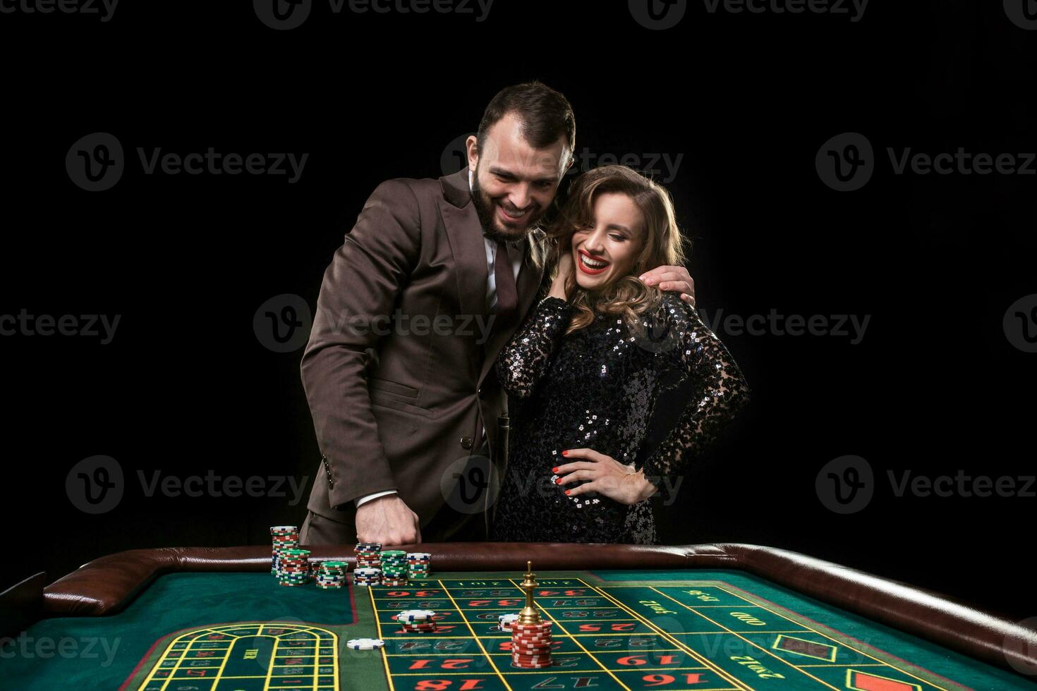 Mens en vrouw spelen Bij roulette tafel in casino foto