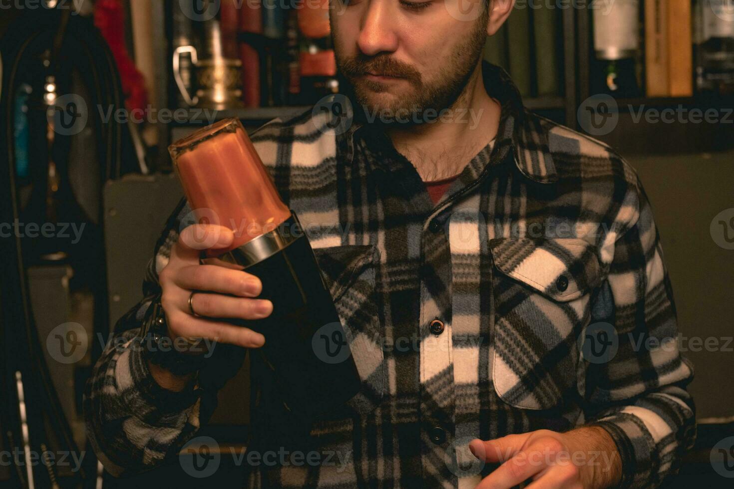 gefocust gebaard barman menging cocktail in shaker in bar foto