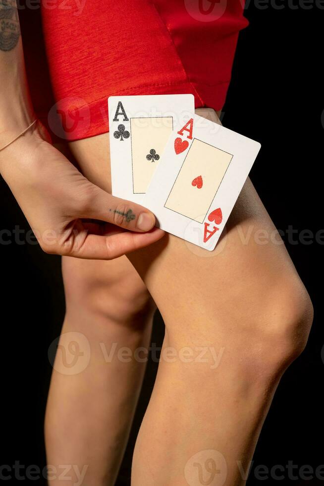 twee azen in vrouw poker speler hand- in de buurt slank blootgesteld poten foto