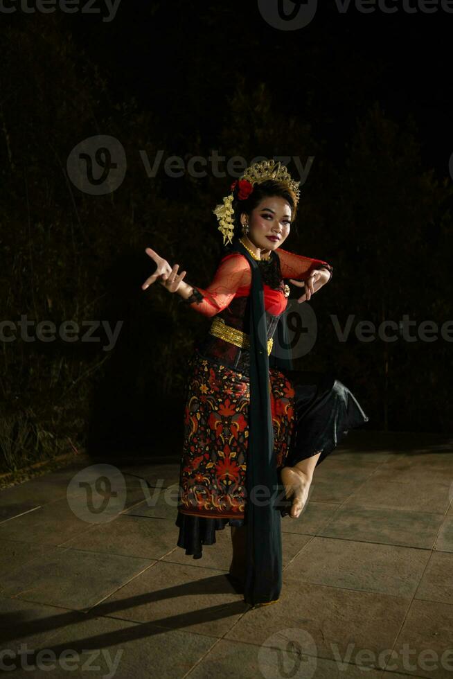 een Indonesisch danser poseren met haar mooi en mooi handen terwijl vervelend bedenken Bij nacht foto