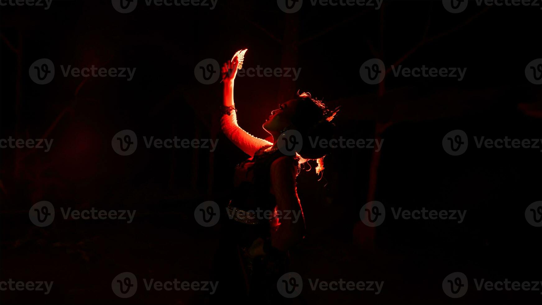 silhouet van een vrouw danser Holding sieraden in de midden- van de stilte van de nacht met rood licht foto