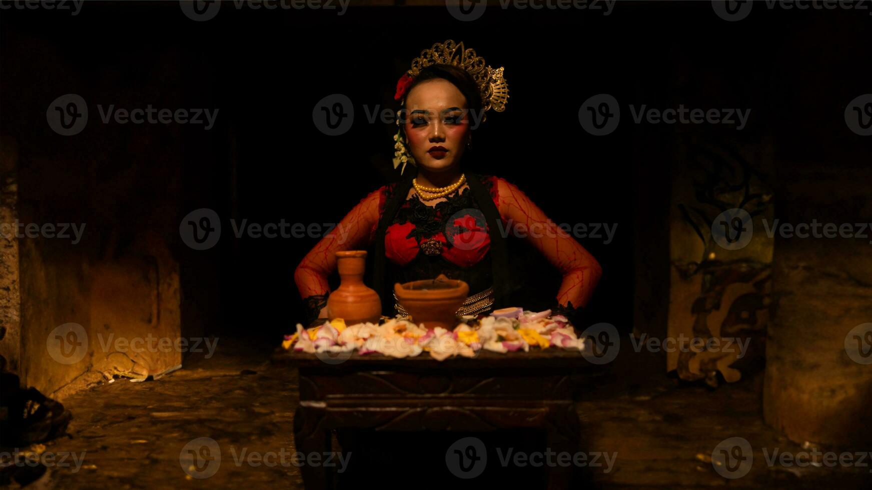 een vrouw danser zit sierlijk en begint haar ritueel in voorkant van mooi aanbiedingen foto