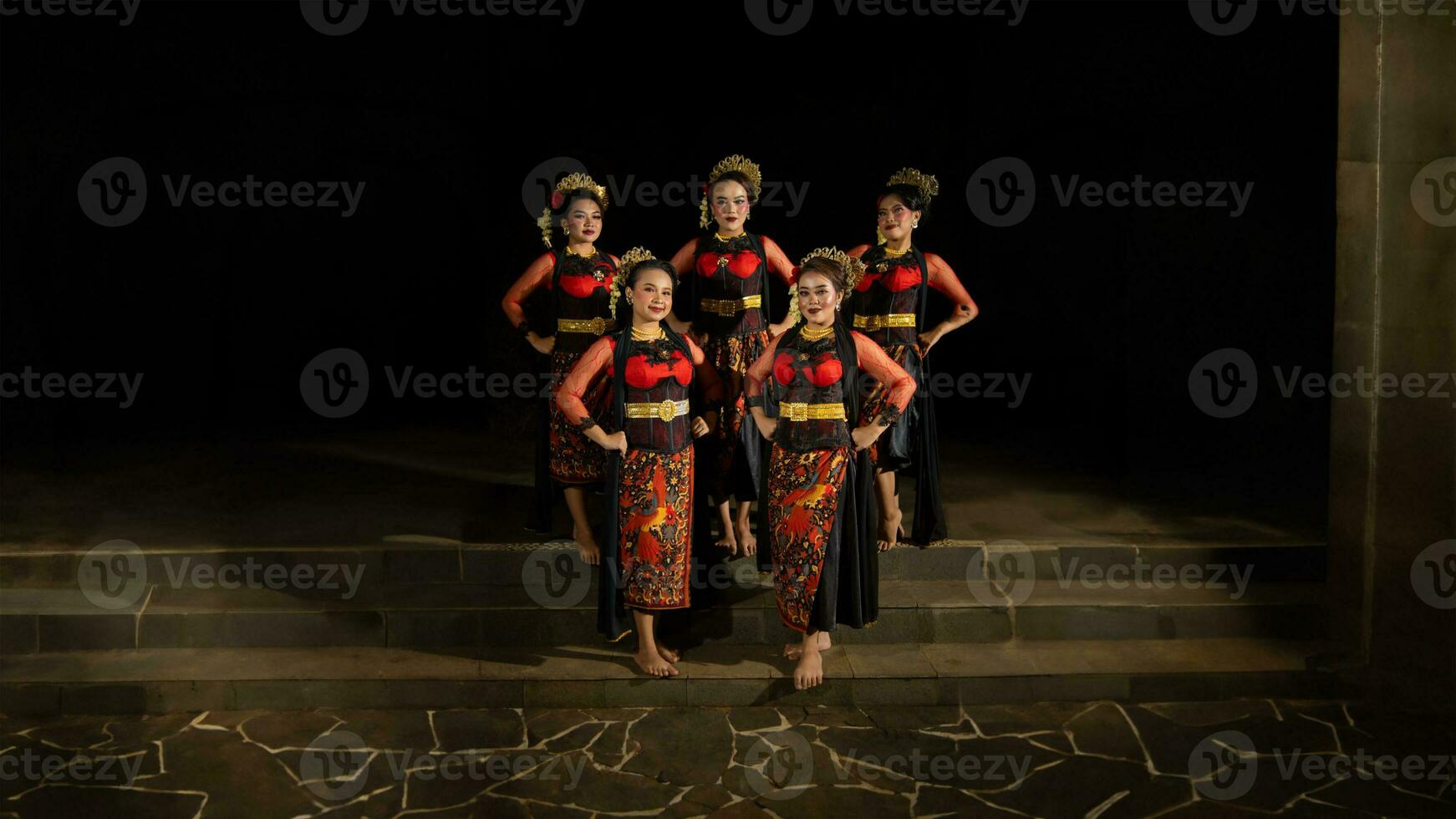 een groep van dansers staan en verenigen in rood kostuums dat tonen eenheid foto