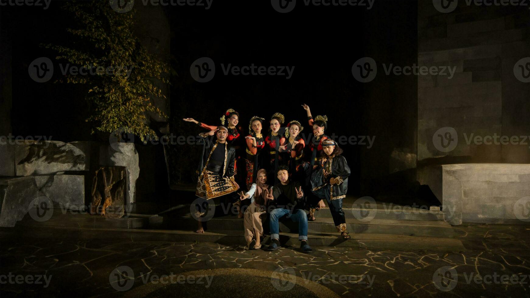 een groep van Indonesisch dansers met gelukkig gelaats uitdrukkingen en op zoek Verenigd wanneer vervelend rood kostuums dat kijken verbijsterend foto