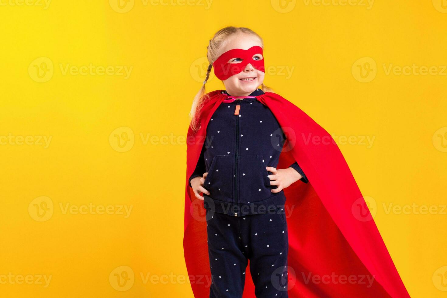 grappig weinig macht superheld kind meisje in een rood regenjas en een masker. superheld concept. foto