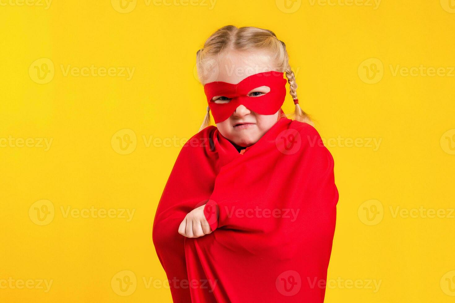 grappig weinig macht superheld kind meisje in een rood regenjas en een masker. superheld concept. foto