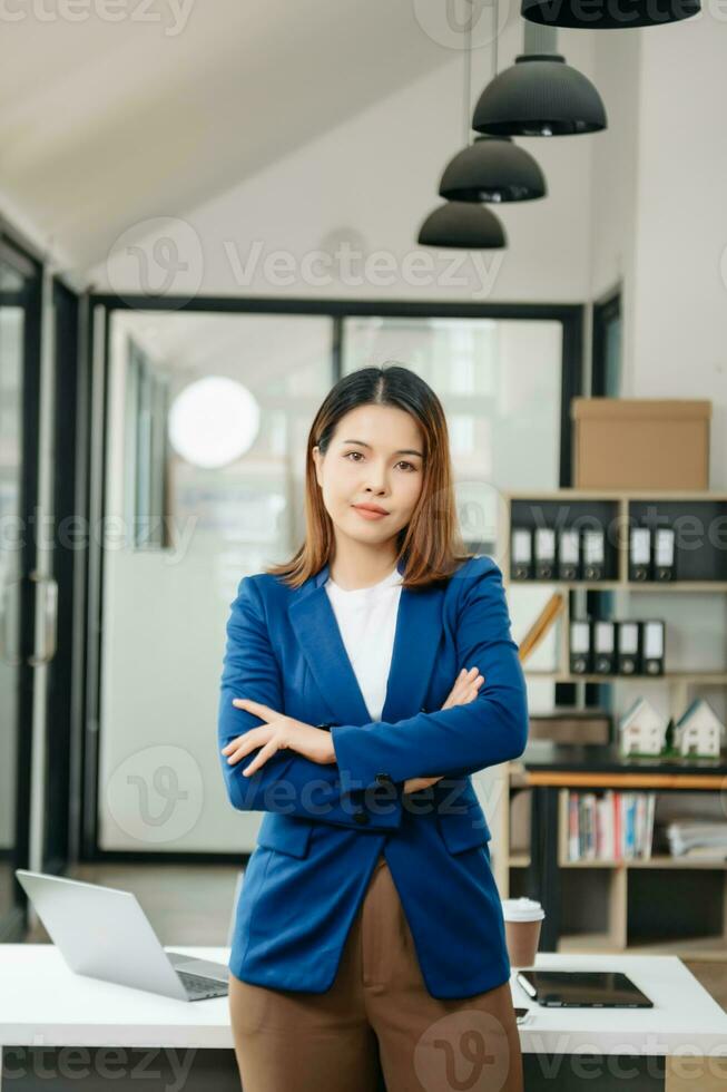 zelfverzekerd bedrijf deskundige aantrekkelijk glimlachen jong vrouw Holding digitaal tablet Aan bureau in creatief kantoor. foto