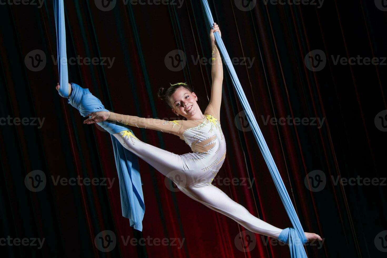 circus artiest acrobaat prestatie Aan doeken. de meisje uitvoeren acrobatisch elementen in de lucht. foto